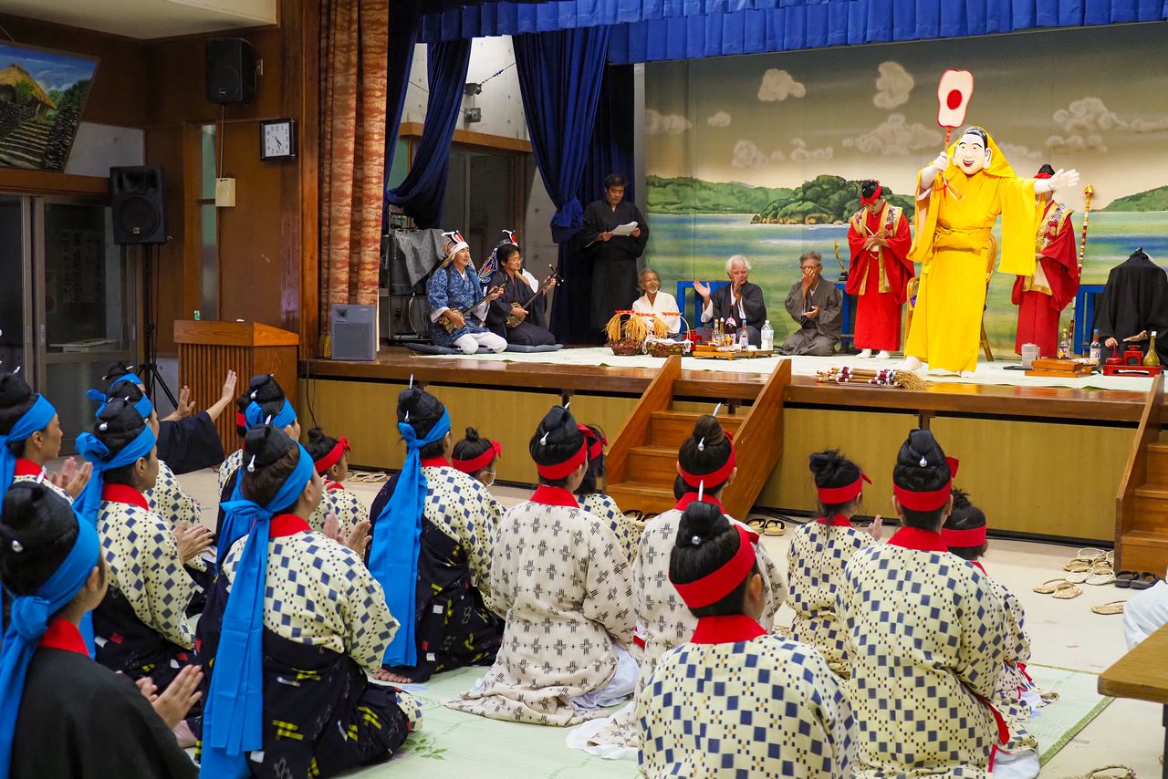 Ceremonia en el centro cívico. Un aldeano se pone la máscara y pide al dios que lo posea.