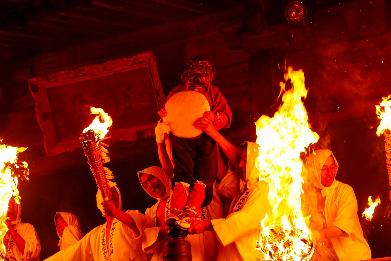 El ogro nieto, con un kagamimochi (pastel de arroz redondo) en las manos, augura buena fortuna para todo el año.