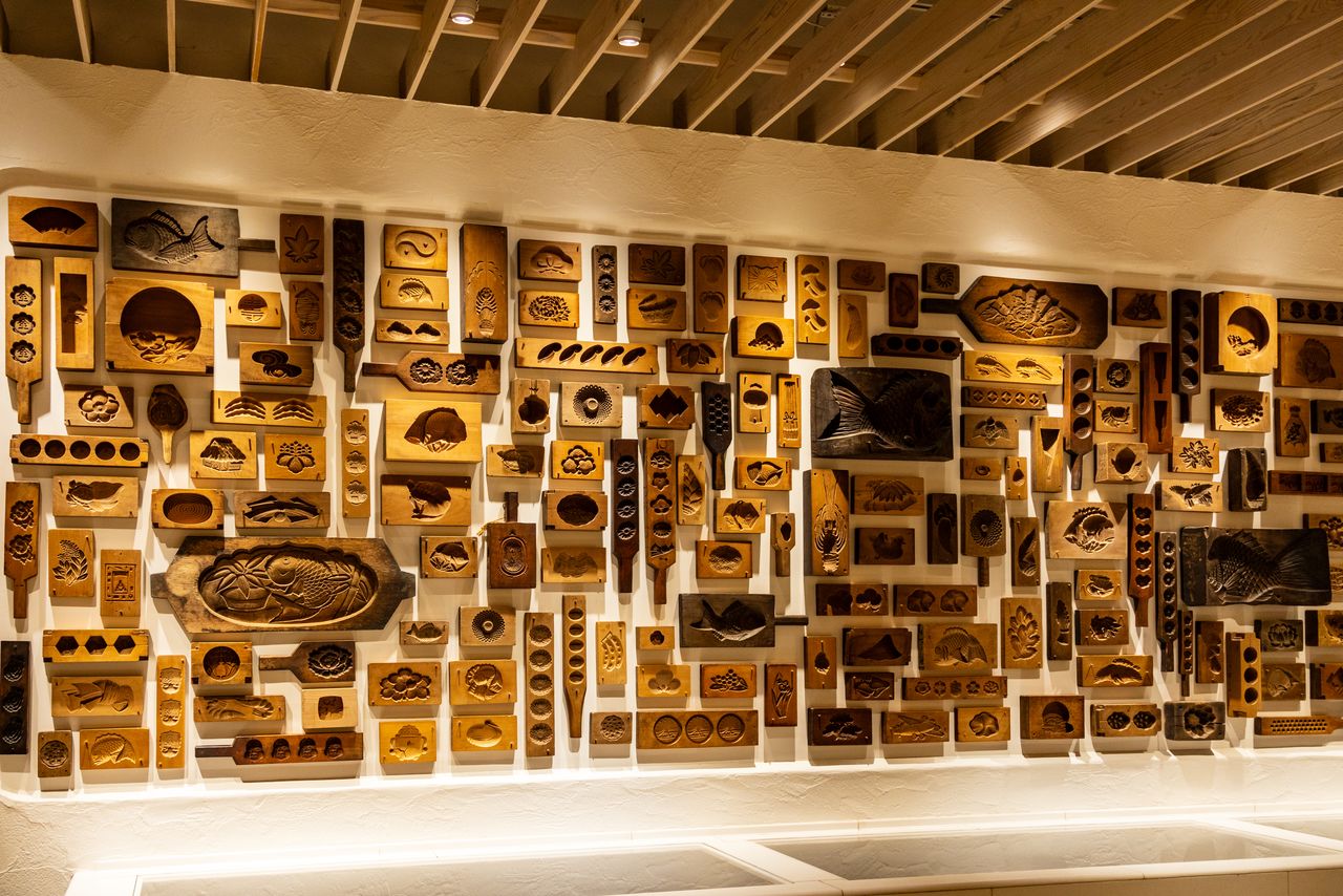 Una pared decorada con moldes de madera para dulces frescos namagashi y panecillos manjū.