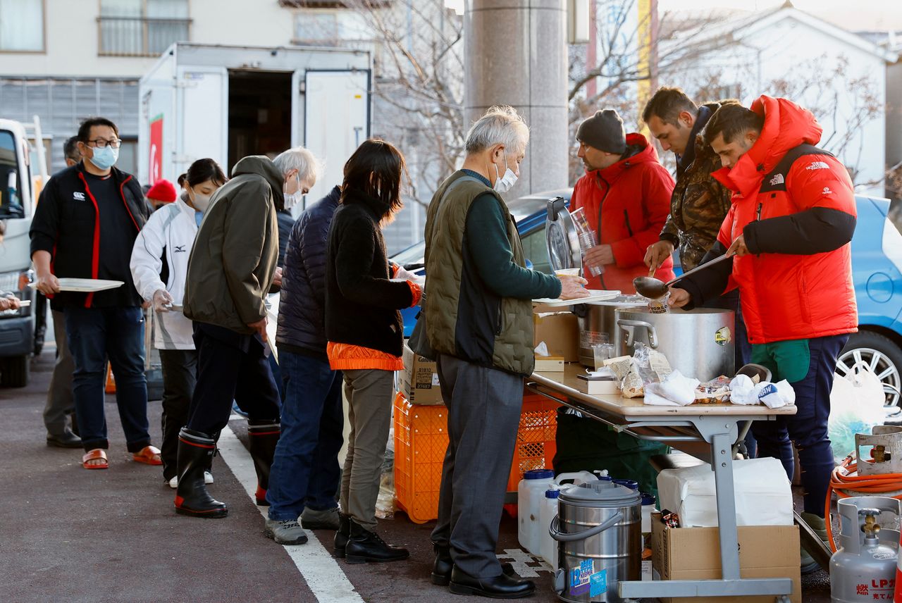 Voluntarios extranjeros repartiendo comida tras el terremoto de Noto, 5 de enero de 2024. (Reuters)