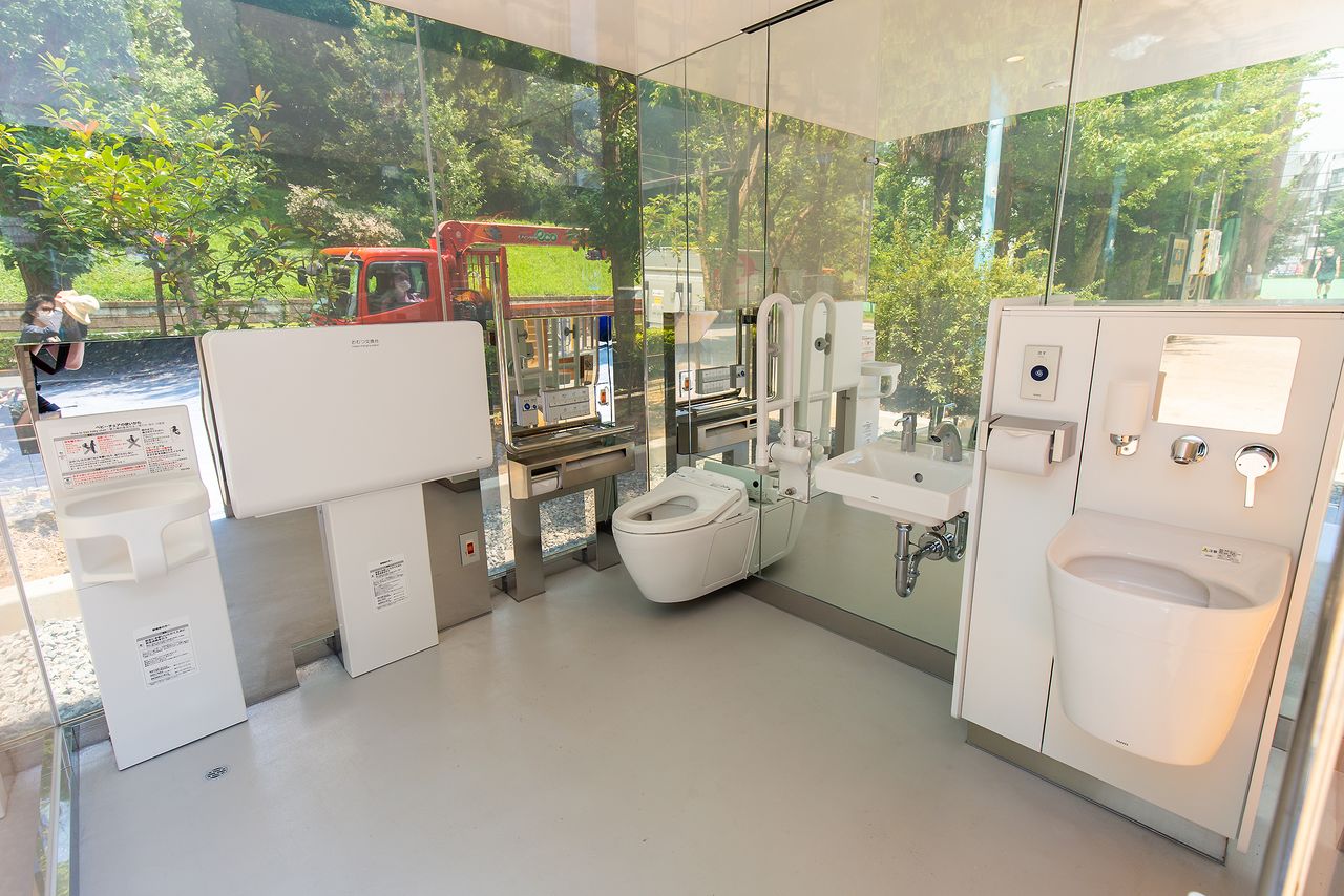 El interior con la puerta abierta. Un baño multiusos que cuenta con cambiador de pañales y retrete para personas ostomizadas.