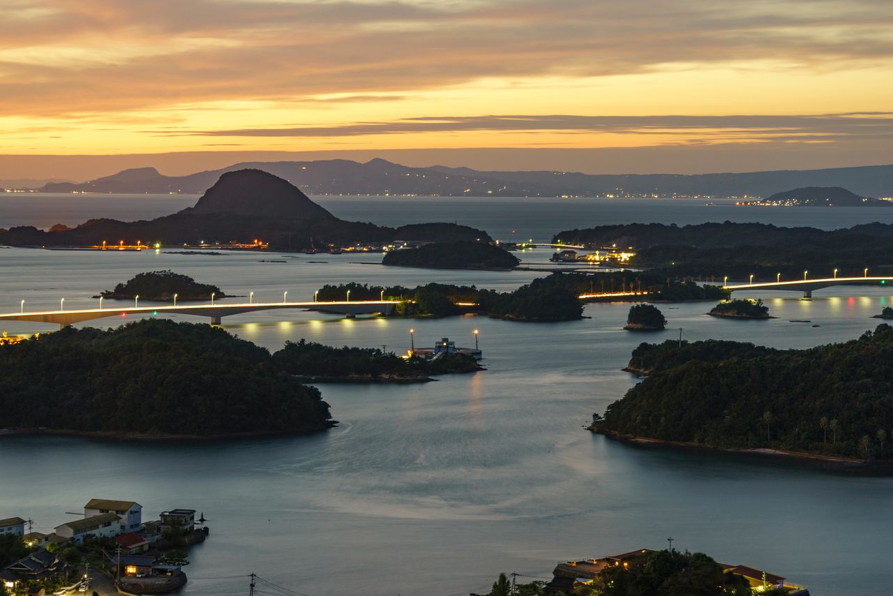La vista nocturna de Amakusa Matsushima desde el mirador del monte Takabuto en Amakusa Kamishima. Al fondo se observa la península de Shimabara. Fotografía: PIXTA.