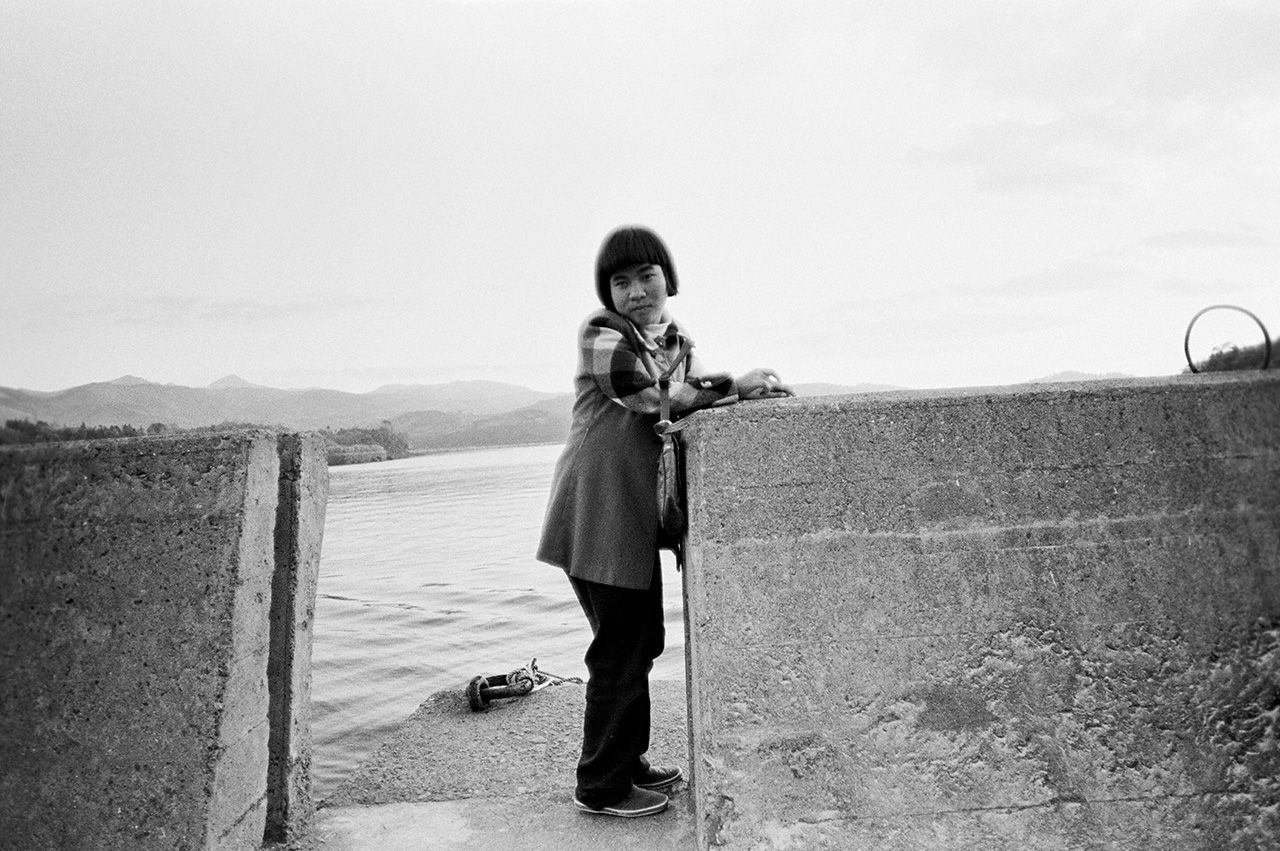 Sakamoto Shinobu: diagnosticada con la enfermedad congénita de Minamata en 1962, a los seis años. En la imagen se apoya en un muro de contención frente a su casa (1972, a sus 16 años).