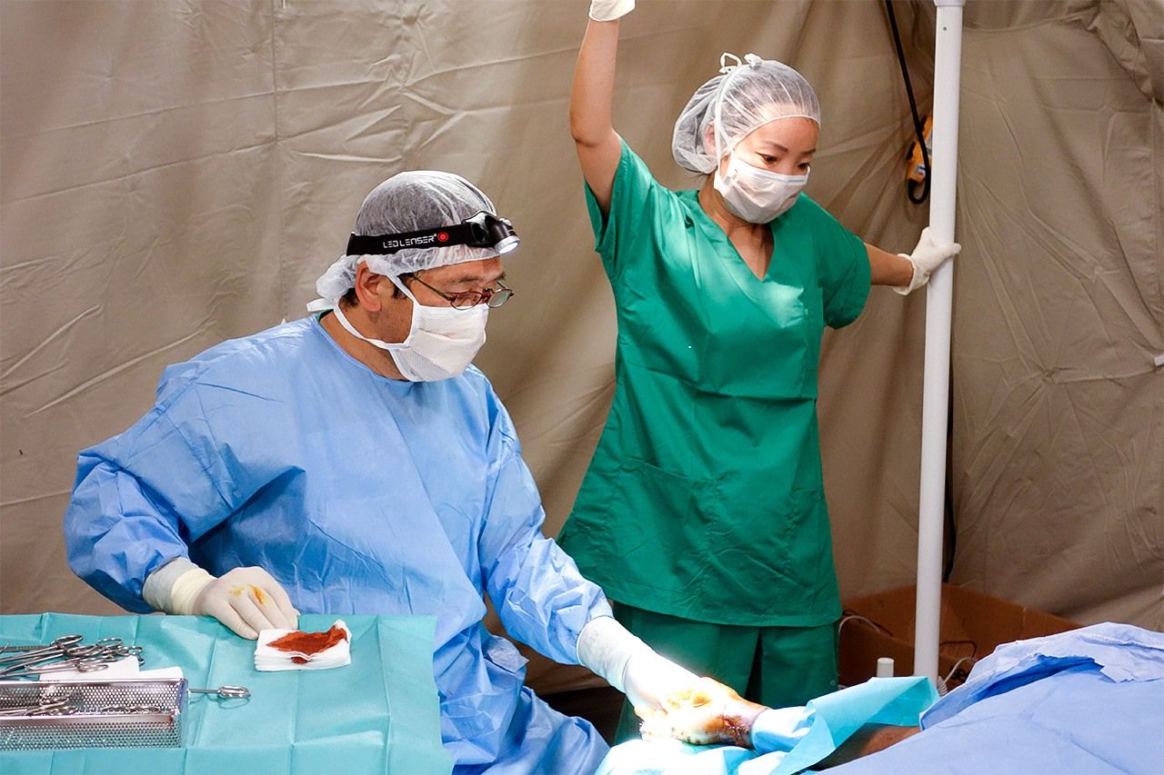 Kurumiya Takashi (izquierda) atendiendo a un herido durante su misión de asistencia médica en Nepal, donde en 2015 hubo un gran terremoto. Ahora Kurumiya quiere concentrar todas sus fuerzas en aumentar la contribución de Japón dentro de la red internacional de MSF, y en las actividades de concienciación de las generaciones más jóvenes. © MSF