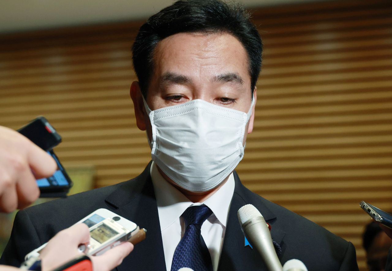 El entonces ministro encargado de la Reconstrucción Económica Yamagiwa Daishirō responde a las preguntas de los informadores después de anunciar su intención de dimitir de su cargo. (Jiji Press)