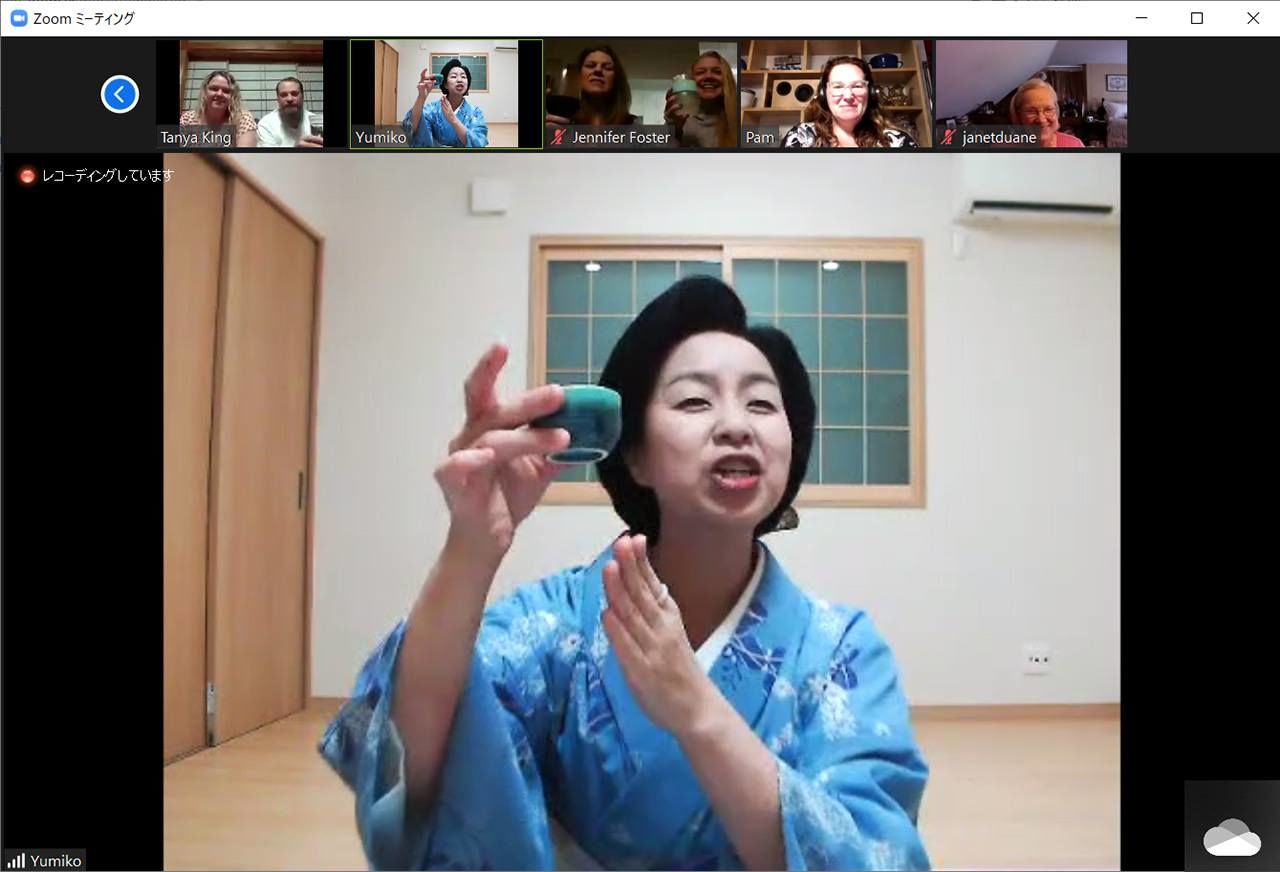 La geisha Yumiko-san brinda mostrando su vasito de cerámica.