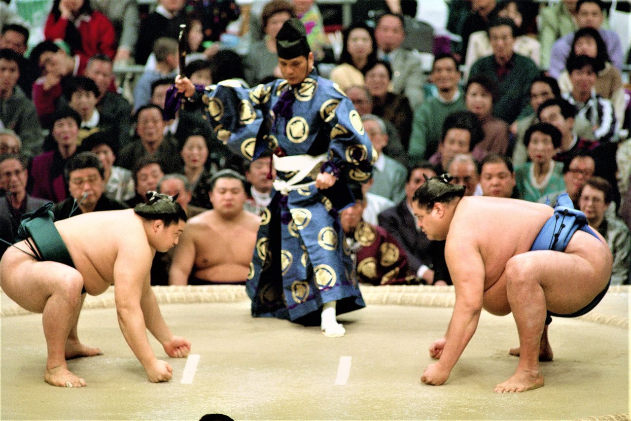 Mirándose a los ojos, los rikishi se ponen de cuclillas y apoyan los puños firmemente en el dohyō. Los encaramientos entre Takanohana y Akebono siempre destilaban dignidad y tensión. (© Jiji Press)