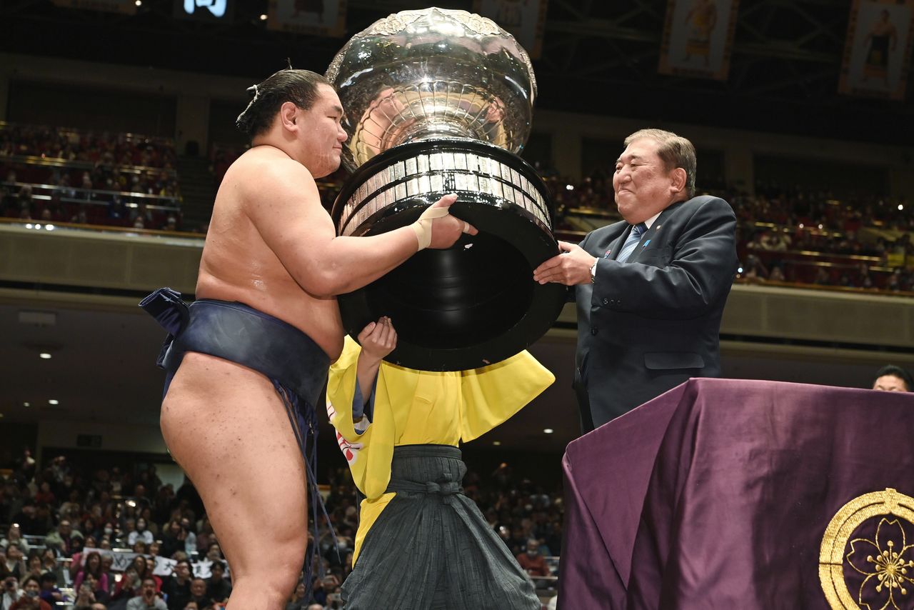Ishiba Shigeru entrega la Copa del Primer Ministro al campeón del torneo, Hōshōryū, en enero de 2025. (© Jiji Press)