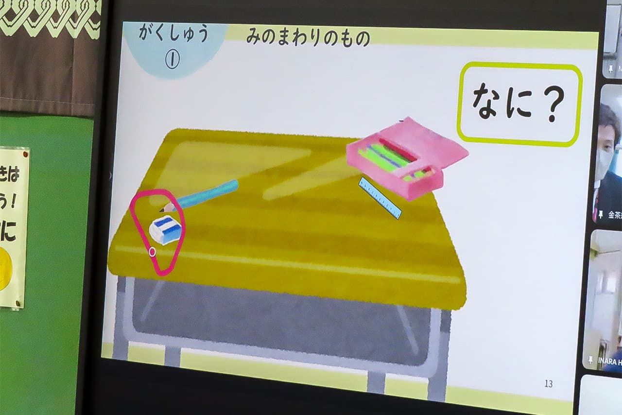 Las anotaciones de la profesora (en este caso, un círculo rojo que señala la goma de borrar situada en la esquina del pupitre) se muestran en tiempo real en las pantallas de los alumnos. (© Tanaka Keitarō)