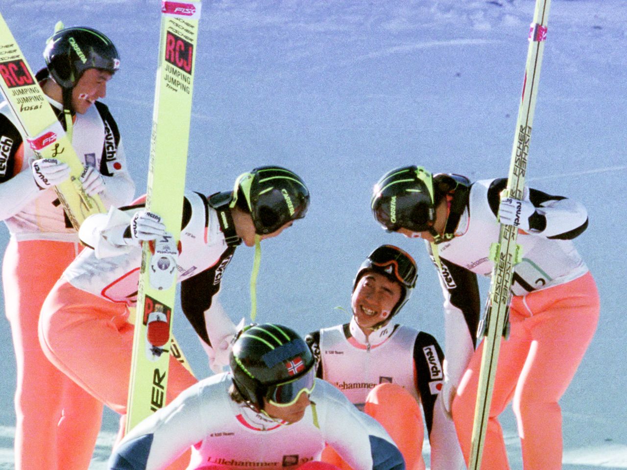 Los compañeros del equipo animan a Harada Masahiko que se agacha tras fallar su segundo salto en la competición de salto de esquí con trampolín grande por equipos. (AFP)
