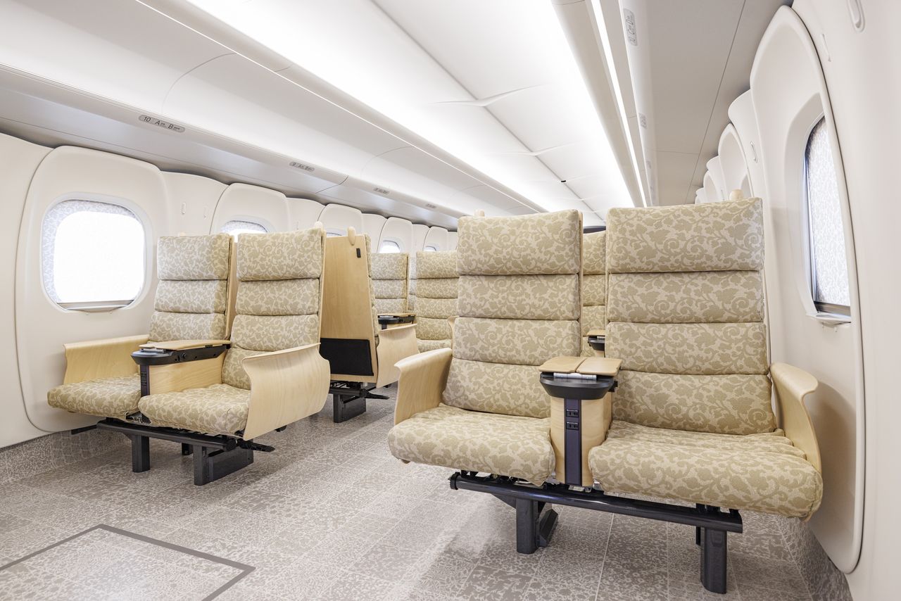 Los asientos reservados tienen diseños de estilo japonés, como el patrón karakusa, entre otros. Para el descansabrazos y la mesita se utilizó madera. (Fotografía de JR Kyūshū) 
