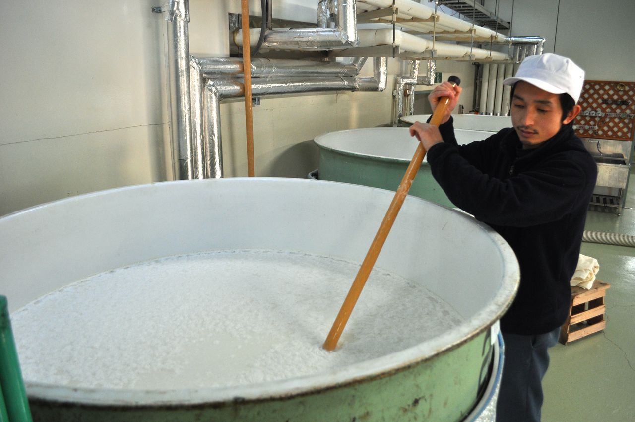 Un tōji (maestro productor) remueve la masa fermentada como parte del proceso de elaboración del sake en la bodega Yamatogawa, en Kitakata, prefectura de Fukushima, en 2015. (© Jiji)