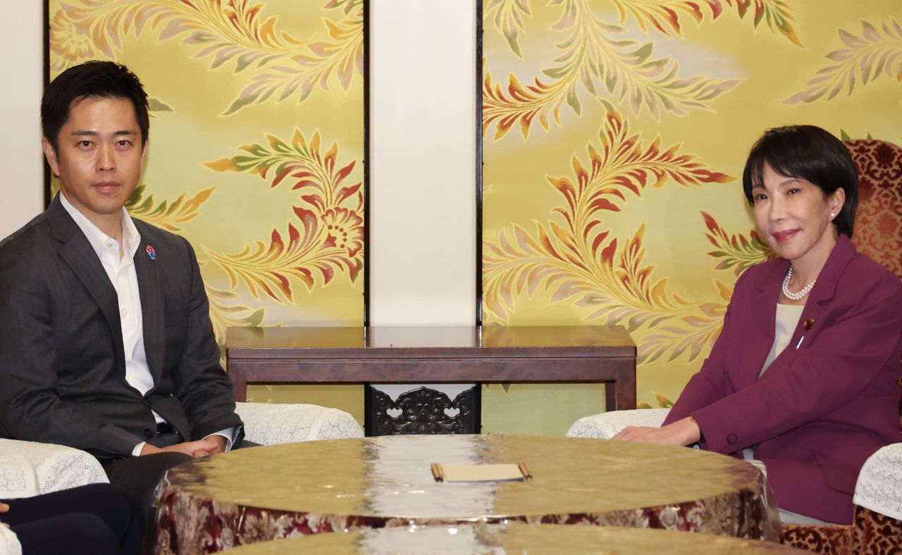 El líder del Nippon Ishin no Kai, Yoshimura Hirofumi (a la izquierda) charla con la presidenta del Partido Liberal Democrático, Takaichi Sanae, el 15 de octubre de 2025. (© Jiji)