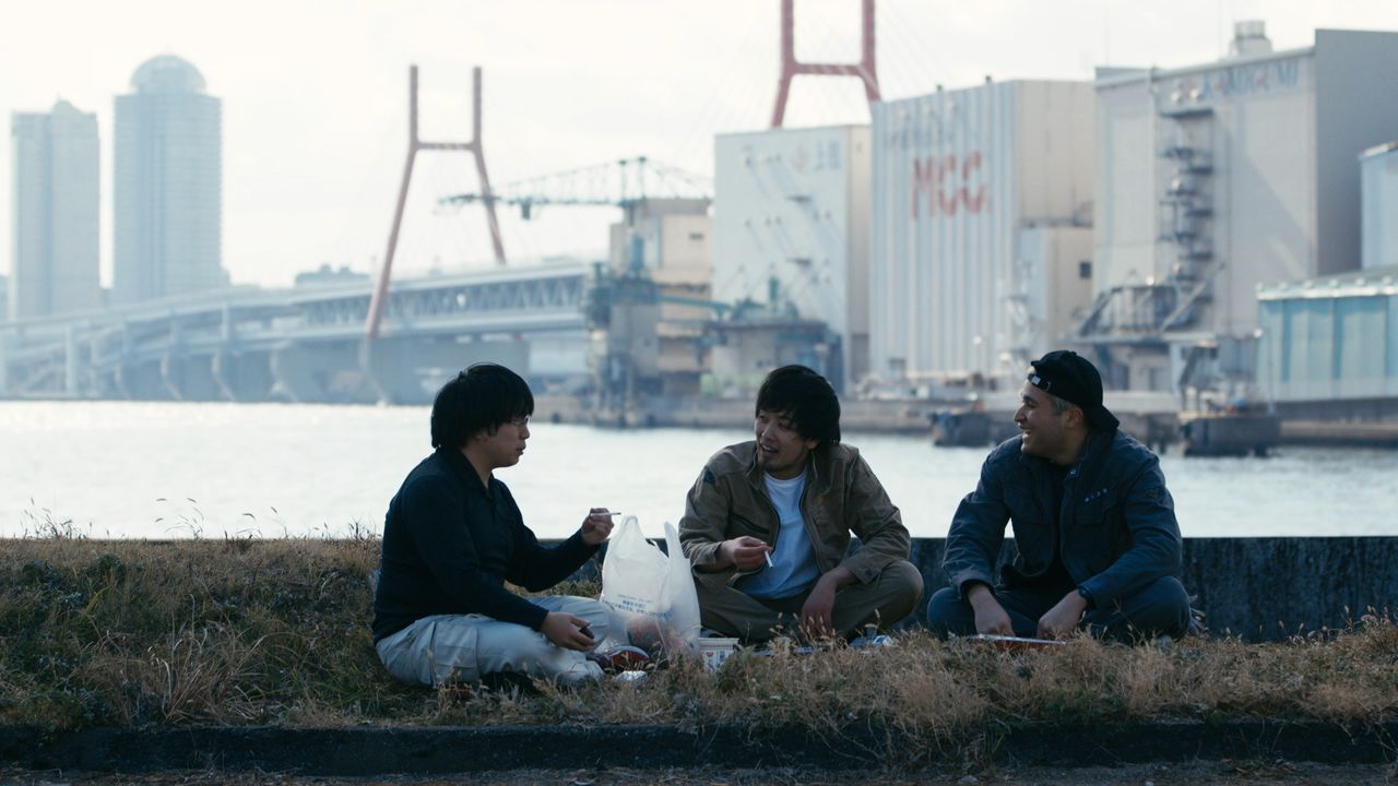 Makoto (extremo derecho) bromeando con sus colegas en una zona de construcción, pese a que carga con angustias que no puede confiar a los demás. (© 078)