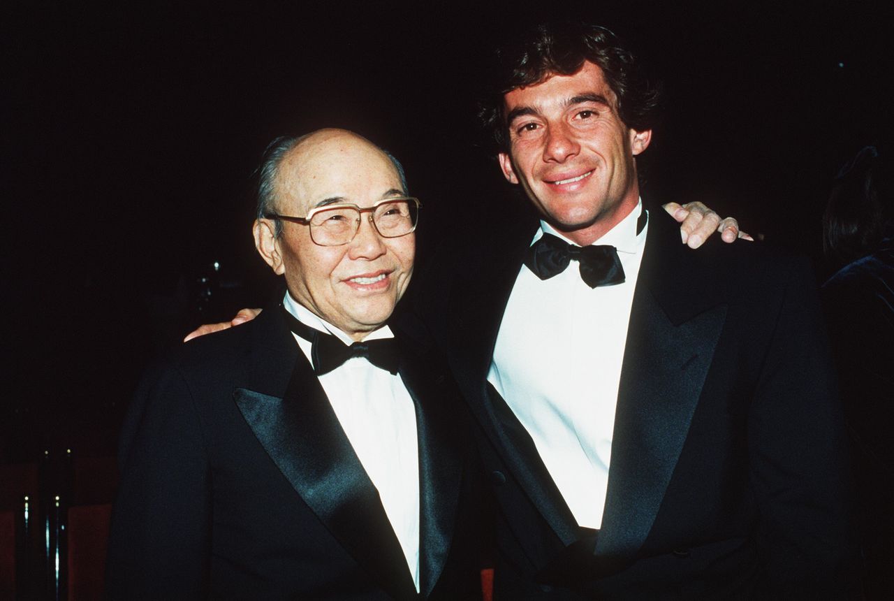 Ayrton Senna, de McLaren-Honda (derecha), y Honda Sōichirō, asesor jefe de Honda, se codean en una fiesta en París, en diciembre de 1990. (AFP)