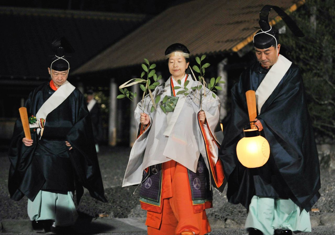 Sayako (al centro) desempeñando sus labores de sacerdotisa principal. En sus manos lleva dos grandes ramas sagradas tamagushi. 5 de octubre de 2013. Pabellón exterior del santuario de Ise, ciudad de Ise, prefectura de Mie. (Fotografía oficial) (Jiji)