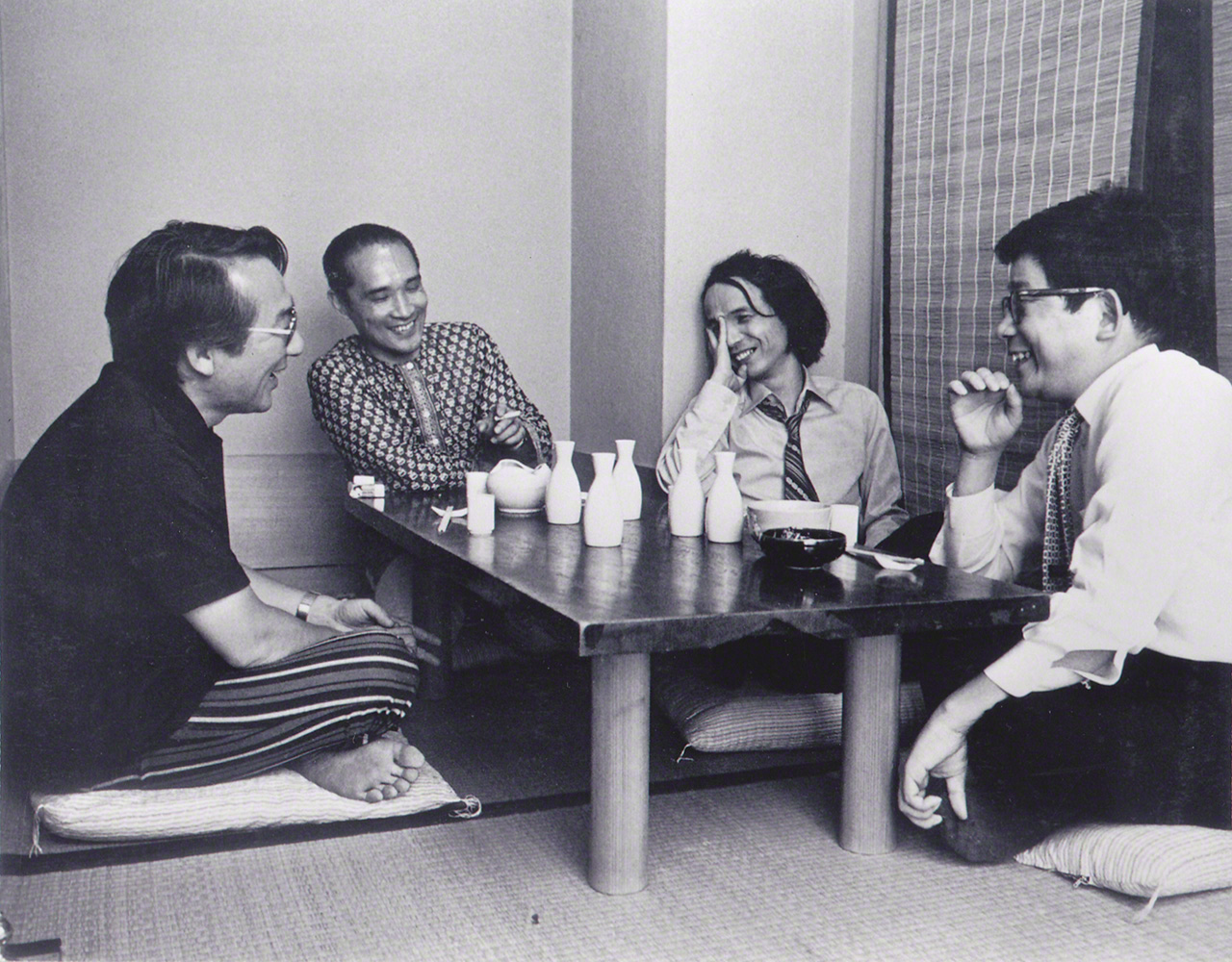 Charlando amistosamente con sus grandes amigos. De izquierda a derecha, el compositor Yuasa Jōji, el poeta Tanikawa Shuntarō, Takemitsu y el escritor Ōe Kenzaburō. Fotografía tomada en los años 70.