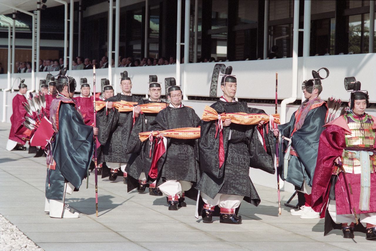 Miembros de la Agencia de la Casa Imperial portan en sus manos las espadas que serán utilizadas en la ceremonia del sokuirei seiden no gi. Fotografía del 12 de noviembre de 1990. (Por cortesía del diario Mainichi y Aflo)