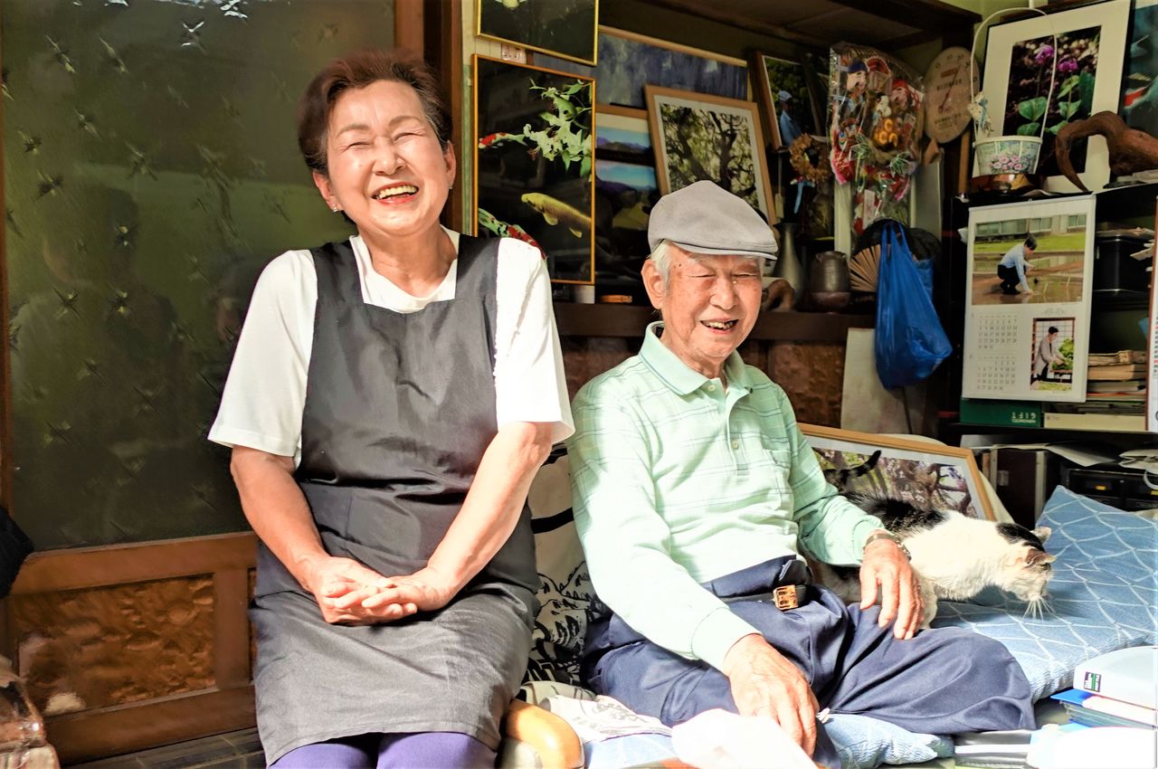 Chūichi con su hija Kazue. Ella también va al monte todos los días para llevar en camioneta a su padre, que devolvió el permiso de conducir a los 90 años. A veces maneja la sierra eléctrica. Les acompaña su gato Shiro. Fotografía: Amano Hisaki.