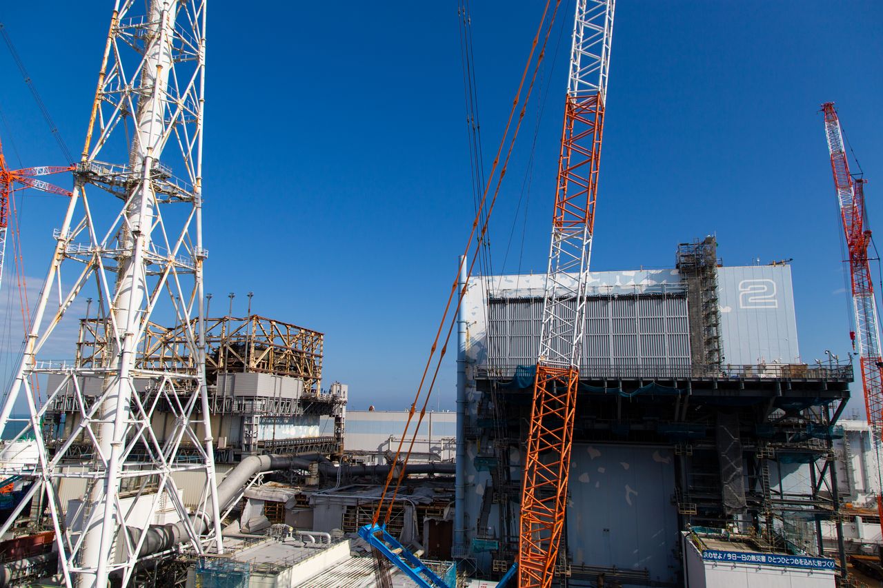 Vista del reactor 1 (a la izquierda, detrás) y el 2 (centro) desde una plataforma. El armazón del edificio, que fue reventado por la explosión de hidrógeno, permanece expuesto.