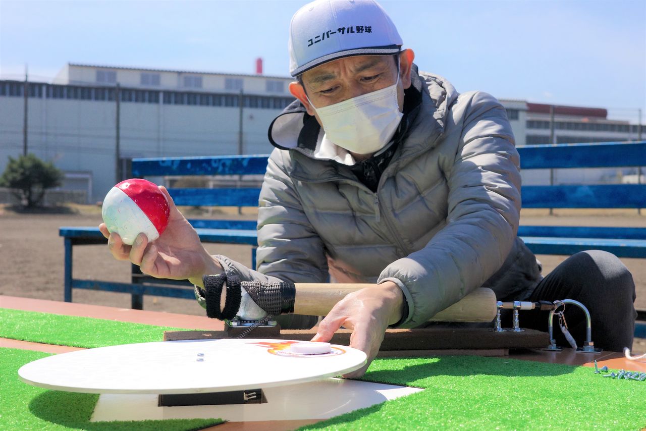 Nakamura ajustando el plato giratorio, la pieza clave del Béisbol Universal.  (Fotografía del autor)