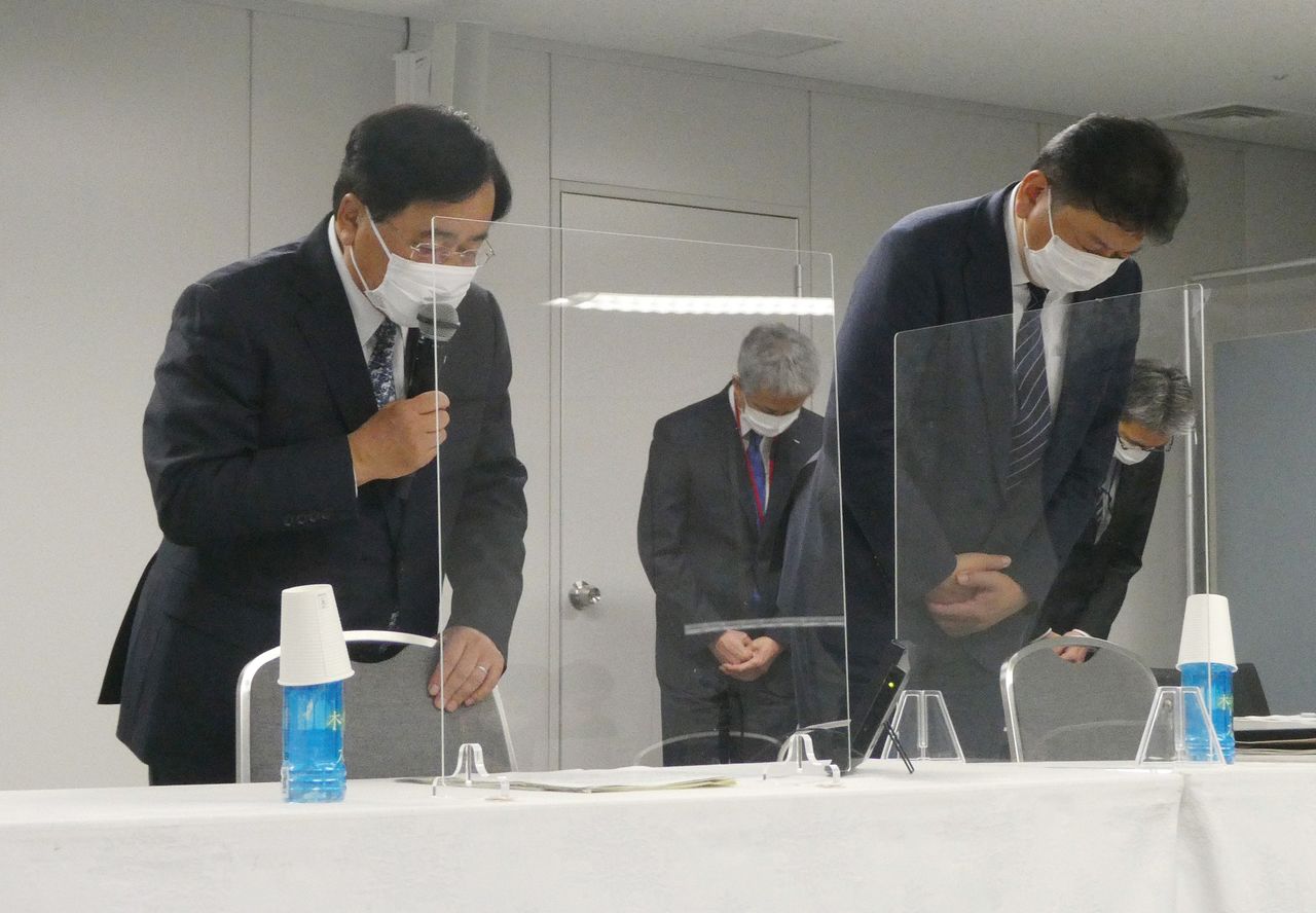 El consejero delegado (CEO) de Tokyo Electric Power Company Holdings, Kobayakawa Tomoaki (derecha), hace una reverencia durante la rueda de prensa en la que explicó las medidas que estaba tomando su empresa para evitar que se repitieran las irregularidades en materia de seguridad descubiertas en la central nuclear de Kashiwazaki-Kariwa. A la izquierda, el presidente Kobayashi Yoshimitsu. (Jiji Press)