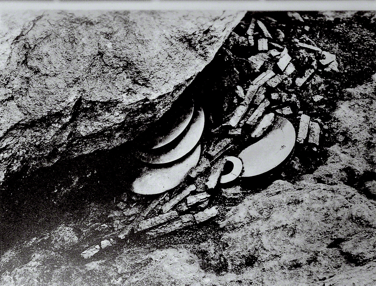 Reliquias desenterradas en el Sitio No. 17. Se hallaron hasta 21 espejos apilados hacia arriba, colocados en los espacios entre las enormes rocas.