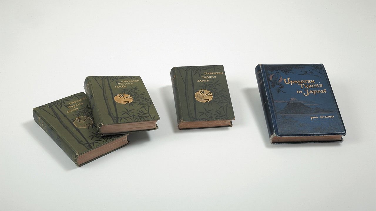 A la izquierda, tres versiones diferentes de Unbeaten Tracks in Japan, de Bird. Desde la izquierda: la edición original en dos volúmenes, publicada en 1880, la edición abreviada de 1885, y la nueva edición publicada en 1900, a la que se añadieron 14 fotografías.