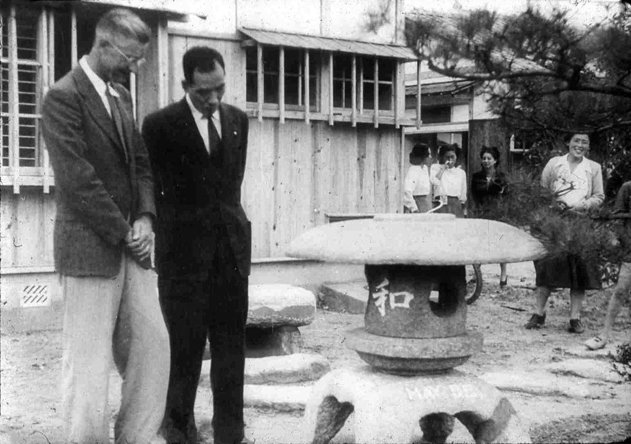 Ceremonia de donación de una de las casas construidas en el barrio de Minami-machi en el proyecto “Houses for Hiroshima”, el 1 de octubre de 1949. Floyd Schmoe (izquierda) aparece junto a Hamai Shinzō, alcalde de la ciudad. Junto a la casa, Schmoe donó una linterna de piedra con la inscripción “Oración por la paz” en japonés. (Cortesía de Tomiko y. Schmoe, colección de la asociación “Schmoe ni manabu kai”)