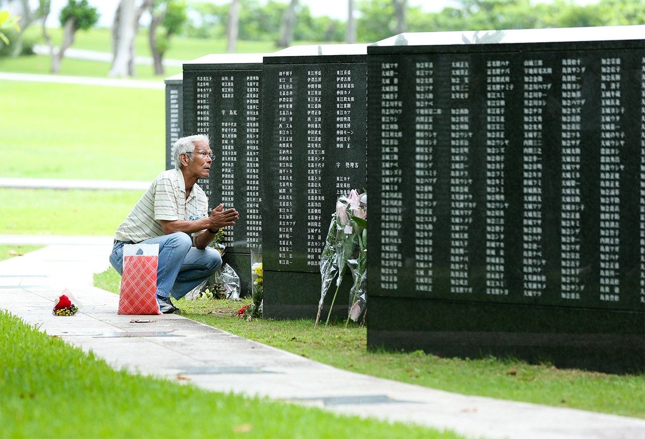 Un hombre, agachado y con las palmas unidas en señal de rezo, delante de la Piedra Angular de la Paz durante el Día Conmemorativo de Okinawa de 2020. (Jiji Press)