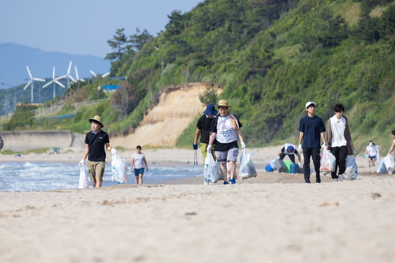 Los participantes experimentan la dureza de caminar sobre la arena bajo el inclemente sol cargando además con la basura recolectada.