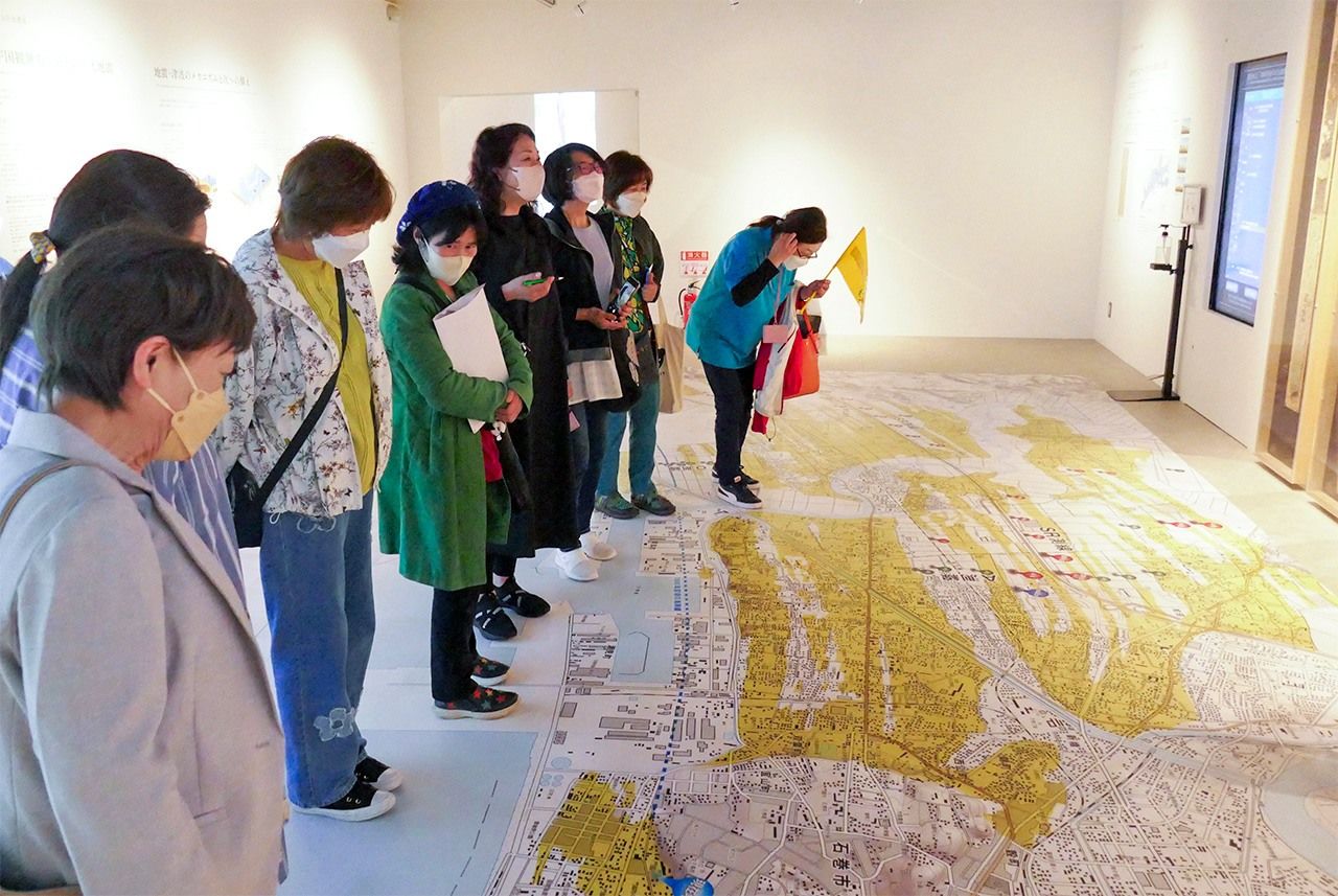 Las participantes observan un mapa de las zonas afectadas por el tsunami en Ishinomaki en las instalaciones de las Ruinas de la Escuela Primaria de Kadonowaki. (Fotografía de la autora)