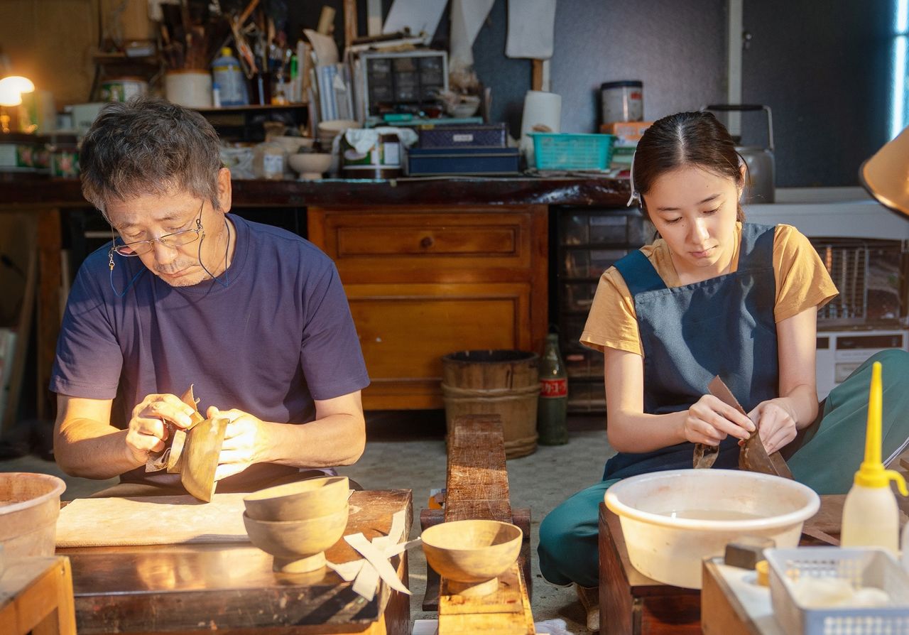 Hotta con Kobayashi Kaoru (izquierda), que da vida a Seishirō, el artesano de lacado Tsugaru. Ambos aprendieron el dialecto de Tsugaru y practicaron lacado por su cuenta. (© 2023 Comité de producción de Baka nuri no musume)