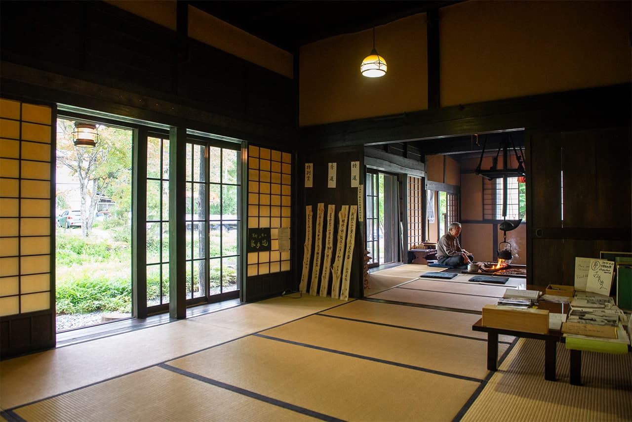 Interior de la villa Mugeisō. En el fondo, Fujimori Mitsuyoshi, sentado frente al hogar, cuenta historias sobre Ozu Yasujirō.