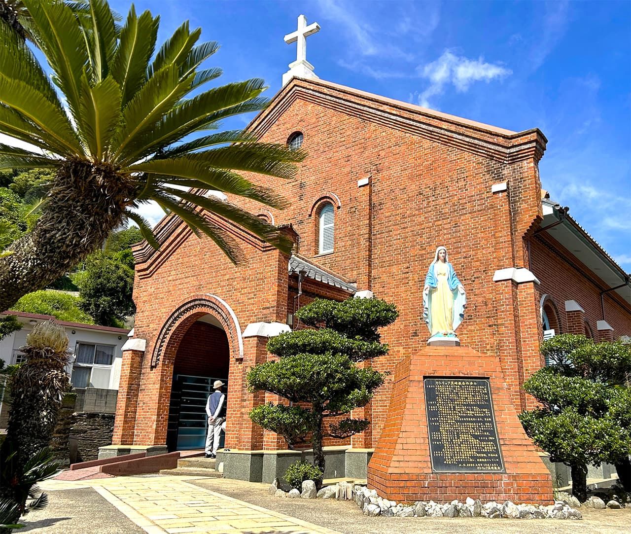 La iglesia de Kurosaki, construida en ladrillo, con su característica estatua de Santa María con ambos brazos abiertos. Quedó completada en 1920. El lugar puede visitarse en autobús, pues se encuentra a unos pasos de la parada Kurosaki Kyōkai-mae. (Fotografía: Amano Hisaki)