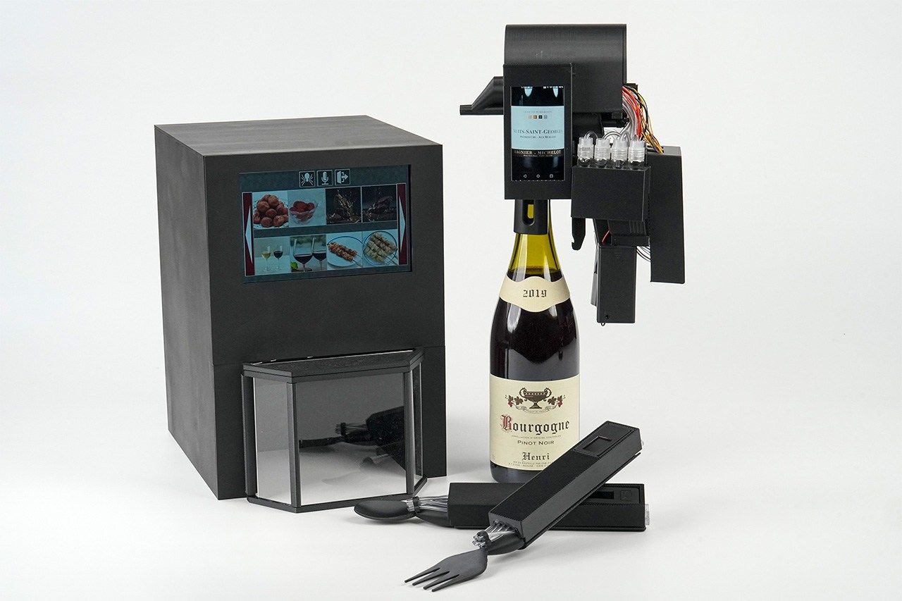 Productos de la serie TTTV desarrollados por el laboratorio de Miyashita. A la izquierda, el TTTV3, un electrodoméstico para dar sabor a los alimentos. A la derecha, el TTTVin, un electrodoméstico que se fija a las botellas, y, en la parte inferior, prototipos de cuchara y tenedor para dar sabor.