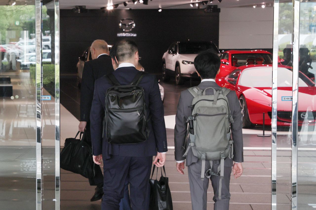 Funcionarios del Ministerio del Territorio, Infraestructuras, Transporte y Turismo entrando en la sede central de Mazda para investigar tras recibir informes de irregularidades. Imagen tomada en Fuchū (Hiroshima) el 10 de junio de 2024. (Jiji Press)