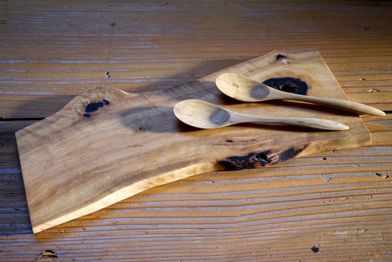 Una tabla de cortar y cucharas de madera de caqui procesada. (© Ukita Yasuyuki)