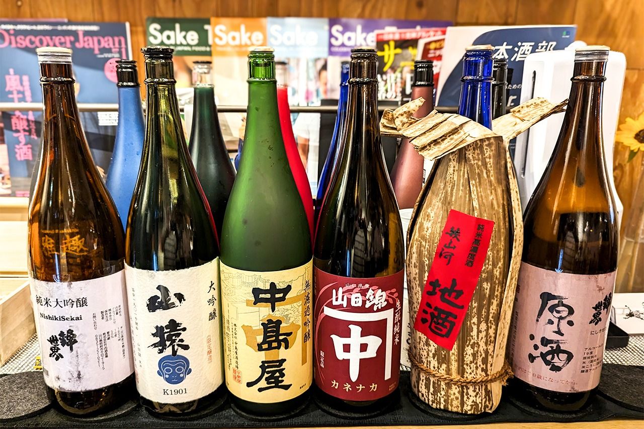 Una variedad de sakes de Yamaguchi que ganó seguidores internacionales en la fiesta de publicación del libro de este autor. De izquierda a derecha: Nishikisekai Junmai Daiginjō de Takeuchi Shuzōjō, Yamazaru Daiginjō de Nagayama Shuzō, Nakashimaya Muroka Ginjō y Kanenaka Kimoto Junmai de Nakashimaya Shuzōjō, Ikuyamakawa Junmai de Kinfundō Shuzō, y Nishikisekai Genshu de Takeuchi Shuzōjō. Son ejemplos de las categorías entre futsūshu y daiginjō. (© Jim Rion)