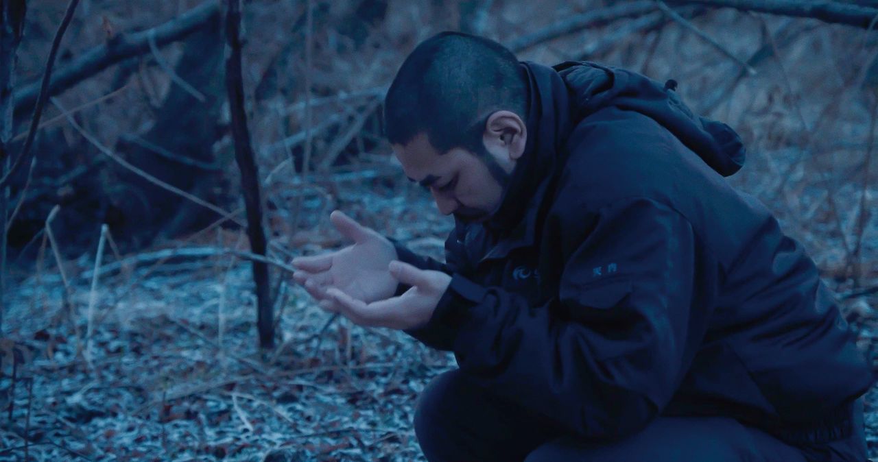 Shige eleva una plegaria a los dioses ante su marep. (© 2024 Takeshi Fukunaga/AINU PURI Production Committee)