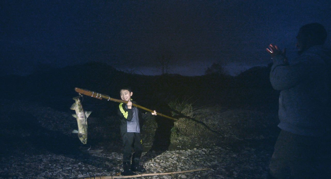 Motoki sostiene una presa con su marep. (© 2024 Takeshi Fukunaga/AINU PURI Production Committee)