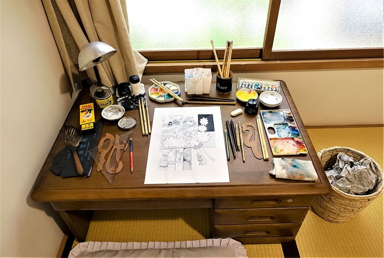 En algunas habitaciones se puede tomar una foto conmemorativa en una mesa de trabajo con una hoja de cómic en proceso (actualmente, esta actividad está suspendida por el coronavirus). Fotografía: Amano Hisaki.