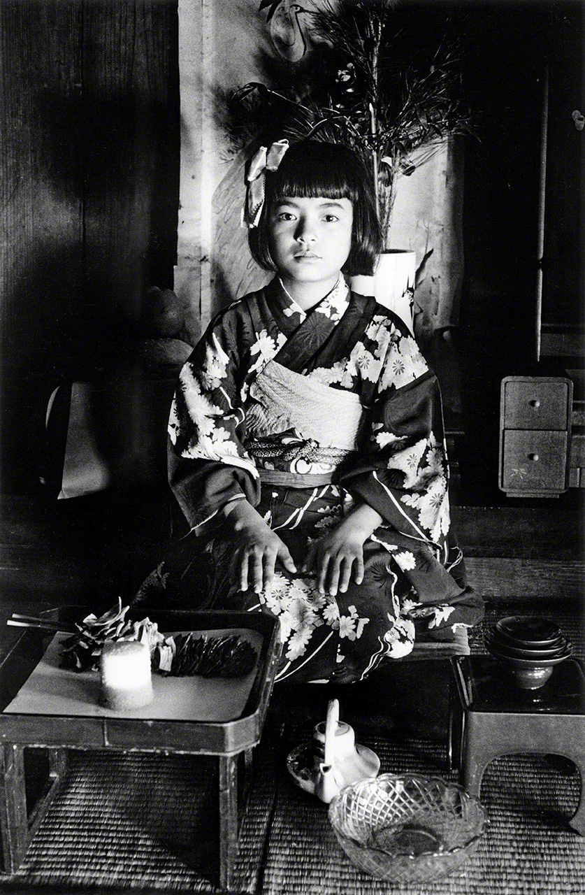 &ldquo;Decimotercer cumplea&ntilde;os&rdquo;. Celebraci&oacute;n del decimotercer cumplea&ntilde;os seg&uacute;n el sistema tradicional japon&eacute;s de c&aacute;lculo de edad. Para las ni&ntilde;as, es la primera y &uacute;ltima ceremonia que se celebra en la casa de sus padres, por lo que se celebra por todo lo alto con el uso de un kimono ceremonial reci&eacute;n confeccionado. La expresi&oacute;n de la ni&ntilde;a, que transmite un nerviosismo palpable, es particularmente llamativa. (Fotografiado en la isla de Okinoerabu, 1957)
