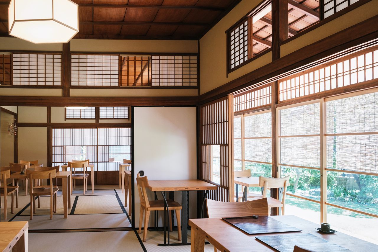 Sala de estilo japonés en la que les han sacado partido a las columnas viejas y al techo original.