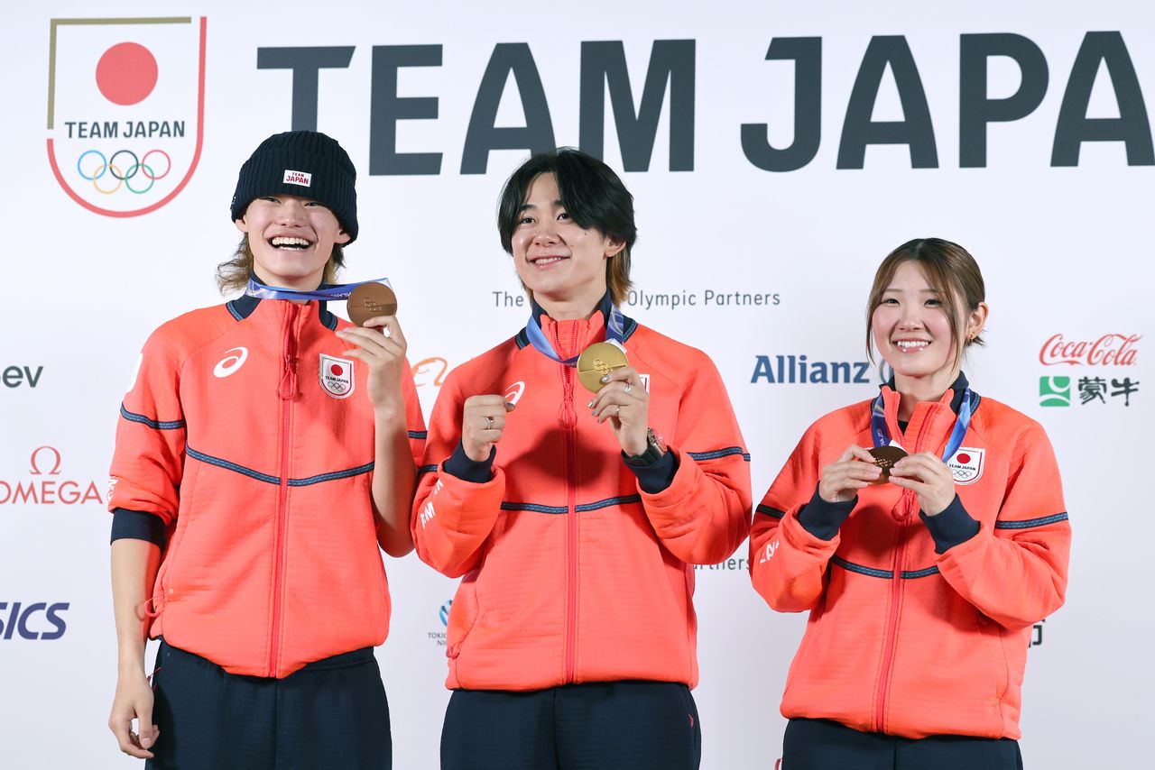 Los medallistas de snowboard sonríen durante una rueda de prensa celebrada el 15 de febrero en Milán. De izquierda a derecha, el medallista de bronce en snowboard halfpipe masculino Yamada Ryūsei, el medallista de oro Totsuka Yūto y la medallista de bronce en snowboard femenino Ono Mitsuki. (© Jiji)