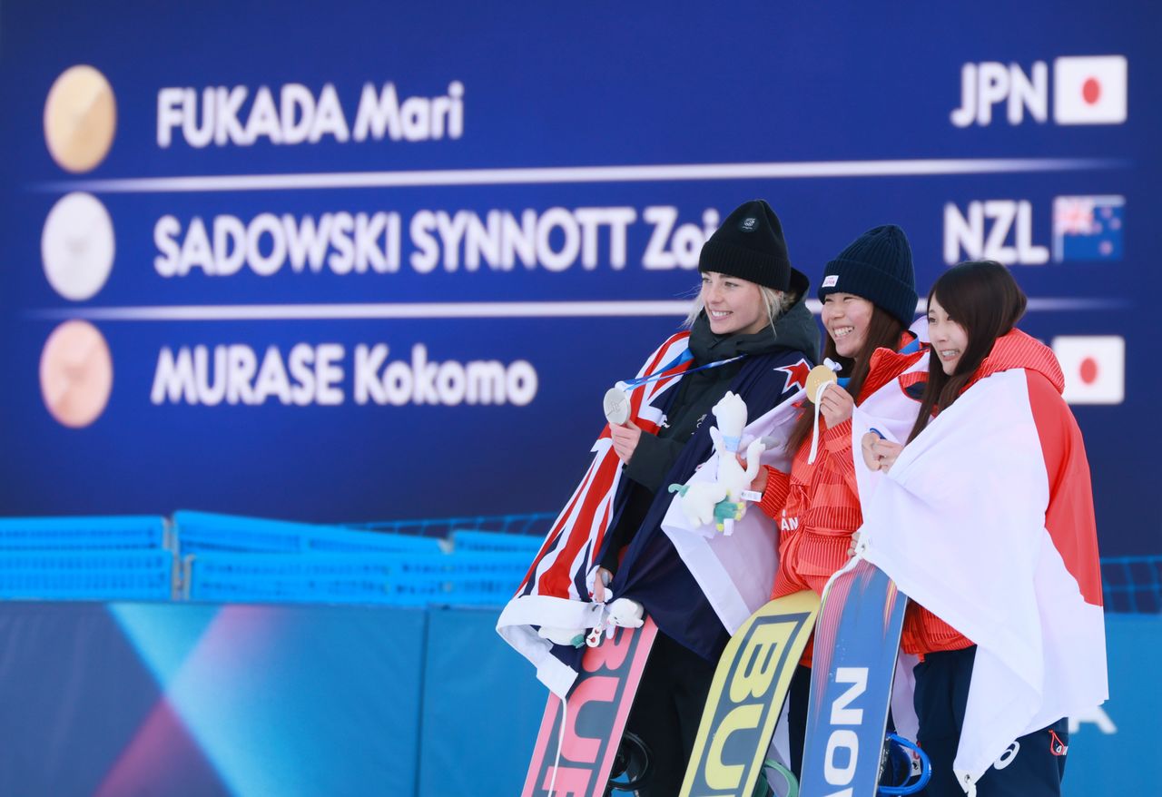 Fukada Mari (centro) sostiene su medalla de oro en snowboard slopestyle femenino. A su derecha está su compañera de equipo y medallista de bronce Murase Kokomo, y a su izquierda la medallista de plata Zoi Sadowski-Synnott, de Nueva Zelanda. Fotografía realizada en Livigno, Italia, el 18 de febrero de 2026. (© Jiji)