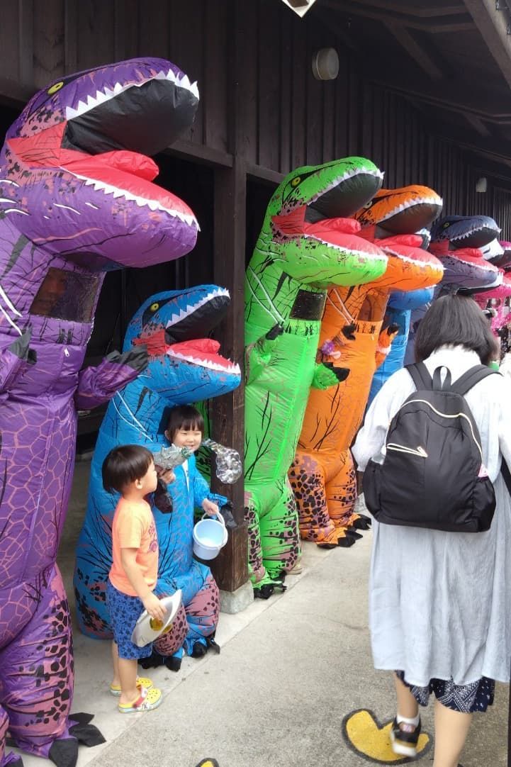 Los “dinosaurios” reciben a los turistas en la estación de Katsuyama, donde se encuentra el museo. Las “crías” (niños) también parecen divertirse. (Fotografía cedida por Watanabe Hiroshi)