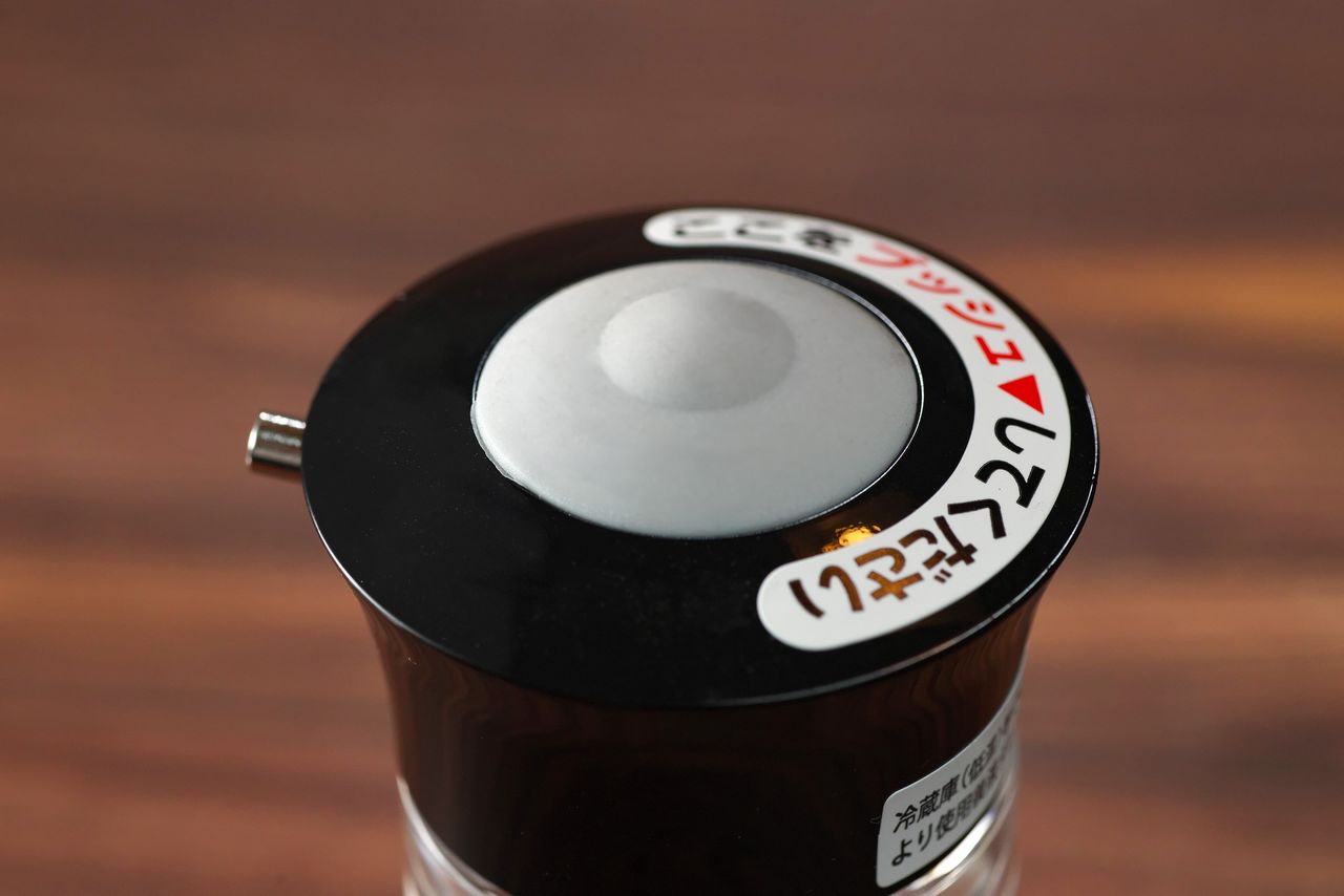 Al apretar el botón de la tapa, la salsa sale gota a gota.
