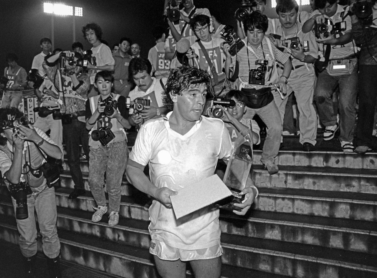 Maradona en 1988, cuando visitó Japón para participar en el Xerox Super Soccer como jugador del Napoli. Estuvo continuamente rodeado de fotógrafos. (Jiji Press).