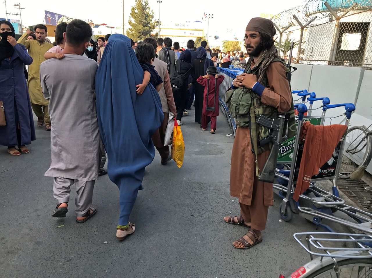 Un miembro de los talibanes monta guardia mientras la gente camina en la puerta de entrada del aeropuerto internacional Hamid Karzai en Kabul, Afganistán, el 16 de agosto de 2021.REUTERS/Stringer